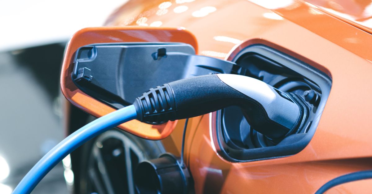 ev charger plugged into an orange electric car